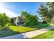 Well-maintained front lawn with lush greenery surrounding a screened patio at 6002 Thrushwood Rd, Lithia, FL 33547