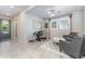 Inviting living space with tiled floors, a ceiling fan, two windows and comfortable seating with a gray color palette at 6002 Thrushwood Rd, Lithia, FL 33547