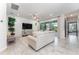 Bright living room featuring tile floors, a comfortable sofa, a large TV, and access to a screened patio at 6002 Thrushwood Rd, Lithia, FL 33547