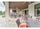 Large covered outdoor patio with fireplace, seating, tv, curtains and lighting for entertaining at 6002 Thrushwood Rd, Lithia, FL 33547