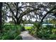 Scenic walking path through lush greenery leads to serene lake views, perfect for relaxation and recreation at 6002 Thrushwood Rd, Lithia, FL 33547