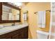 Charming bathroom featuring a wood vanity, marble countertops, and a decorative framed mirror at 6262 142Nd N Ave # 904, Clearwater, FL 33760