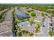 Aerial view of community with central pond, water feature, pool and clubhouse surrounded by trees at 7001 Interbay Blvd # 290, Tampa, FL 33616