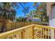 View of a new wooden deck overlooking the backyard with a new fence and blue house beyond at 750 E Harbor S Dr, St Petersburg, FL 33705