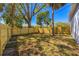 Spacious backyard enclosed by a newly constructed wooden fence with mature trees at 750 E Harbor S Dr, St Petersburg, FL 33705