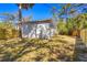 View of a fenced backyard with lush trees, and a house with a small deck at 750 E Harbor S Dr, St Petersburg, FL 33705