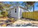 Charming gray home featuring a new, natural wood fence with a spacious driveway at 750 E Harbor S Dr, St Petersburg, FL 33705