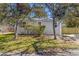 Cozy gray house featuring verdant lawn, shrubs, and a new, natural wood fence at 750 E Harbor S Dr, St Petersburg, FL 33705