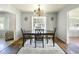 A dining room with a chandelier, a wooden table, 4 chairs, a white rug, and hardwood floors at 801 37Th S Ave, St Petersburg, FL 33705