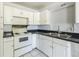 Kitchen features white cabinets, black countertops, and stainless steel sink at 801 37Th S Ave, St Petersburg, FL 33705