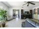 A living room with a ceiling fan, potted plant, and a view of the dining room at 801 37Th S Ave, St Petersburg, FL 33705