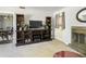 A living room with a fireplace, sectional couch, display case, and a view of the dining room at 801 37Th S Ave, St Petersburg, FL 33705