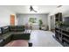 A living room with a sectional sofa, ceiling fan, potted plant and large window at 801 37Th S Ave, St Petersburg, FL 33705