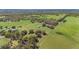 An aerial view shows a expansive property with a mix of grass, woods and multiple buildings at 808 Old Welcome Rd, Lithia, FL 33547