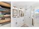 Bright bathroom featuring double sink vanity, wood-framed mirrors, and glass-enclosed shower at 808 Old Welcome Rd, Lithia, FL 33547