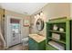Unique bathroom features green vanity, oval mirror, and a door leading to the outside patio at 808 Old Welcome Rd, Lithia, FL 33547