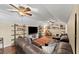 Cozy bonus room with a large sectional sofa, hardwood floors, ceiling fans, and built-in bookshelves at 808 Old Welcome Rd, Lithia, FL 33547
