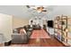 Cozy bonus room with a large sectional sofa, hardwood floors, ceiling fans, and built-in bookshelves at 808 Old Welcome Rd, Lithia, FL 33547