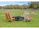 A charming outdoor fire pit area with four wooden rocking chairs sits on a spacious lawn at 808 Old Welcome Rd, Lithia, FL 33547