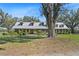 Charming home with a metal roof, dormer windows, and a well-maintained lawn surrounded by mature trees at 808 Old Welcome Rd, Lithia, FL 33547