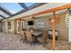 Charming outdoor dining area with a grill, TV, and serene backyard views at 808 Old Welcome Rd, Lithia, FL 33547