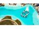 Stunning aerial view of community lagoon with inflatable obstacle course and white sandy beach at 8261 Ivy Stark Blvd, Wesley Chapel, FL 33545