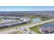An aerial view showcases a Primary-planned community featuring tree-lined streets and scenic ponds at 8261 Ivy Stark Blvd, Wesley Chapel, FL 33545