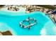 Aerial view of the amazing turquoise pool with a playground slide and beach at 8261 Ivy Stark Blvd, Wesley Chapel, FL 33545