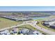 An aerial view captures a well-designed community featuring a roundabout, landscaping, and nearby ponds at 8261 Ivy Stark Blvd, Wesley Chapel, FL 33545