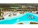Aerial shot of community lagoon with water slides, beach area and lots of shady lounge chairs at 8261 Ivy Stark Blvd, Wesley Chapel, FL 33545