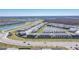 An aerial view shows a Primary-planned community with modern homes along winding roads and tranquil lakes at 8261 Ivy Stark Blvd, Wesley Chapel, FL 33545
