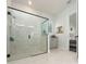 Modern bathroom featuring a glass shower with black trim, marble tile, and neutral-toned cabinets at 8261 Ivy Stark Blvd, Wesley Chapel, FL 33545
