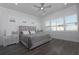Elegant bedroom with neutral tones, natural light, ceiling fan, and laminate wood flooring at 8261 Ivy Stark Blvd, Wesley Chapel, FL 33545