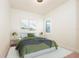 Bedroom with a neatly made bed, two side tables, and light fixtures, offering a simple aesthetic at 8261 Ivy Stark Blvd, Wesley Chapel, FL 33545