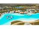 Stunning aerial view of the community pool featuring a water park, cabanas, and pristine aqua-blue waters at 8261 Ivy Stark Blvd, Wesley Chapel, FL 33545