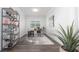 Bright home office with modern decor, sleek desk, gray and white rug, and stylish decorative shelving unit at 8261 Ivy Stark Blvd, Wesley Chapel, FL 33545