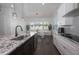 View of a bright kitchen leading to a dining area featuring white cabinets, and granite countertops at 8261 Ivy Stark Blvd, Wesley Chapel, FL 33545
