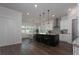 Bright kitchen with a granite countertop island, modern appliances, and dark hardwood floors at 8261 Ivy Stark Blvd, Wesley Chapel, FL 33545