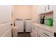 A laundry room with modern appliances, white cabinets, and ample counter space at 8261 Ivy Stark Blvd, Wesley Chapel, FL 33545