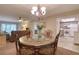 An ornate chandelier illuminates the dining area adjacent to the kitchen and living room at 865 Virginia Ct # 106, Dunedin, FL 34698