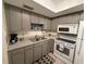 Functional kitchen features grey cabinets, white appliances, and ample counter space at 865 Virginia Ct # 106, Dunedin, FL 34698