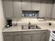 Featuring grey cabinets, a stainless steel sink, and grey countertops at 865 Virginia Ct # 106, Dunedin, FL 34698
