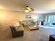 Cozy living room with ceiling fan, comfortable seating, work space and access to a screened patio at 865 Virginia Ct # 106, Dunedin, FL 34698