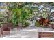 Outdoor seating area with chairs surrounded by lush greenery and trees creating a serene environment at 865 Virginia Ct # 106, Dunedin, FL 34698
