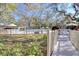 Grassy area with a pool, lounge chairs, and mature trees in the background, creating a tranquil ambiance at 865 Virginia Ct # 106, Dunedin, FL 34698