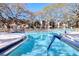Swimming pool with crystal-clear water, surrounded by lounge chairs on a sunny day at 865 Virginia Ct # 106, Dunedin, FL 34698