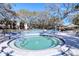 Outdoor spa and pool surrounded by lounge chairs and beautiful mature trees offering shade at 865 Virginia Ct # 106, Dunedin, FL 34698