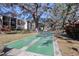 Outdoor shuffleboard court for residents in a community setting with mature trees and lush landscaping at 865 Virginia Ct # 106, Dunedin, FL 34698