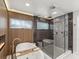 Bathroom features a modern bathtub, walk-in shower, and wood-paneled wall for a relaxing, spa-like feel at 8693 15Th N St, St Petersburg, FL 33702