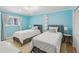 Charming bedroom with dual beds, aqua walls, shuttered windows, and decorative chandelier at 8693 15Th N St, St Petersburg, FL 33702